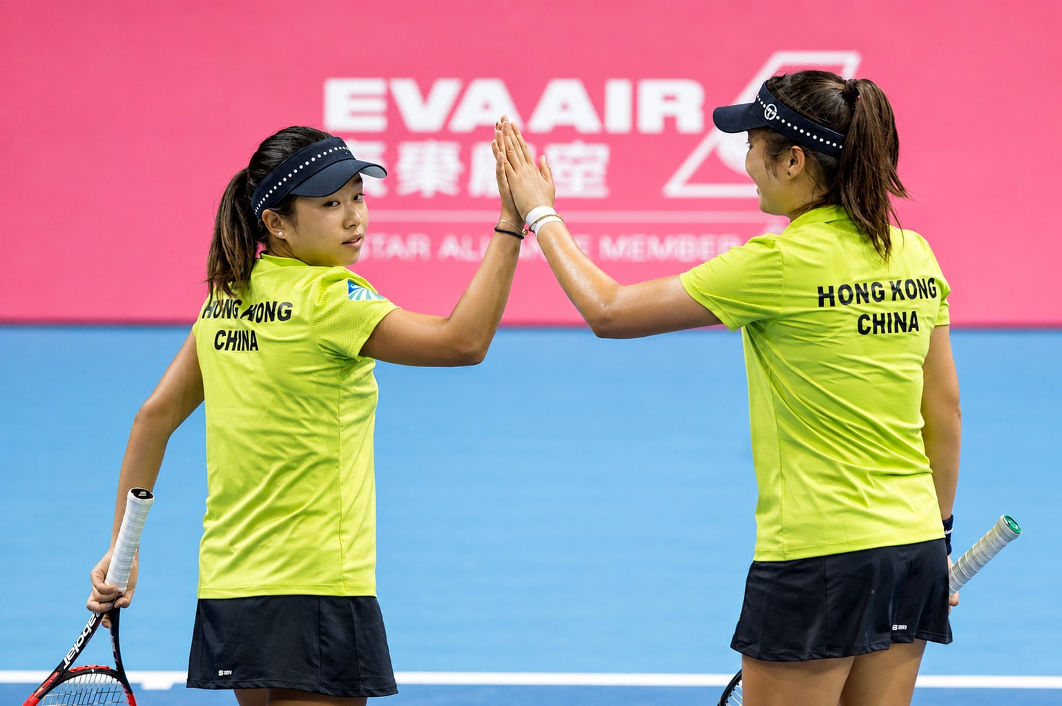 Two Hong Kong China doubles players high-fiving between points.